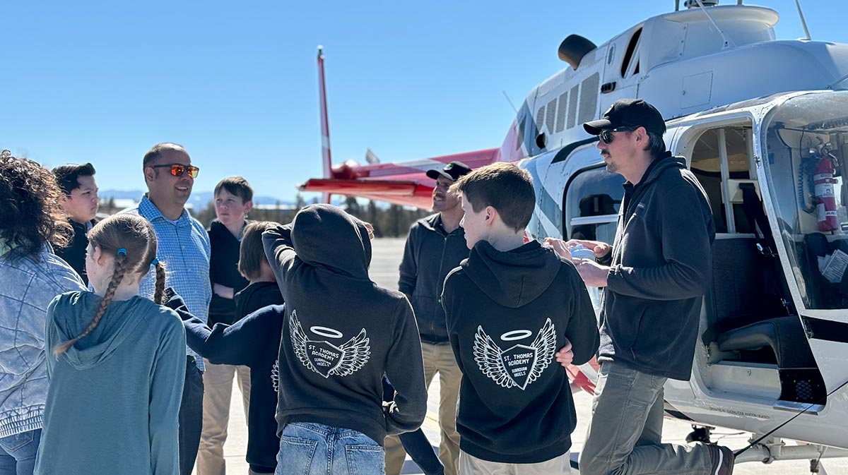 young aviation students with instructors next to helicopter for a blog about volunteer pilots